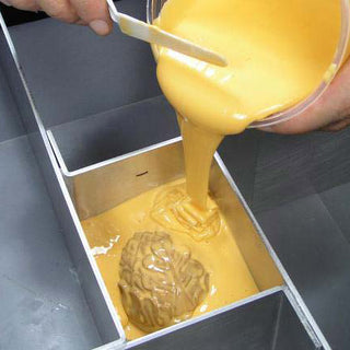 Pouring Liquid Food Safe Silicone Over an Object Mounted in a Mold Box